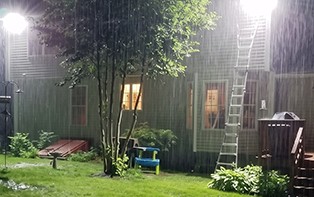 A home lit by a wall pack in heavy rain